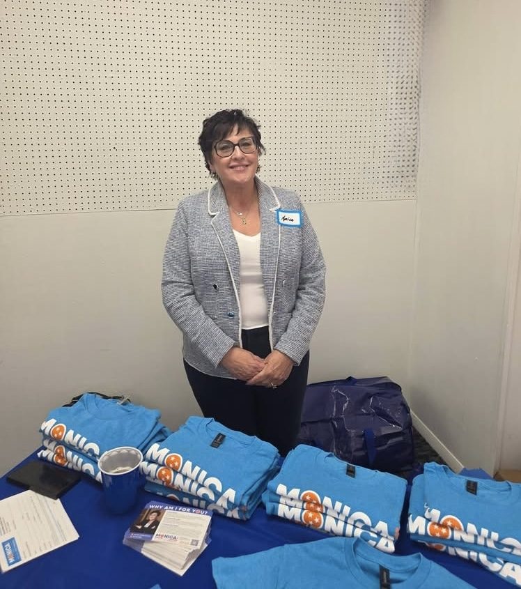 Monica at her campaign table with shirts and campaign materials