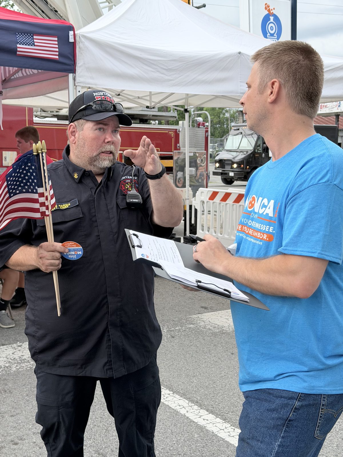 A volunteer talking with a fairgoer at the Monterey Fire in the Mountain festival